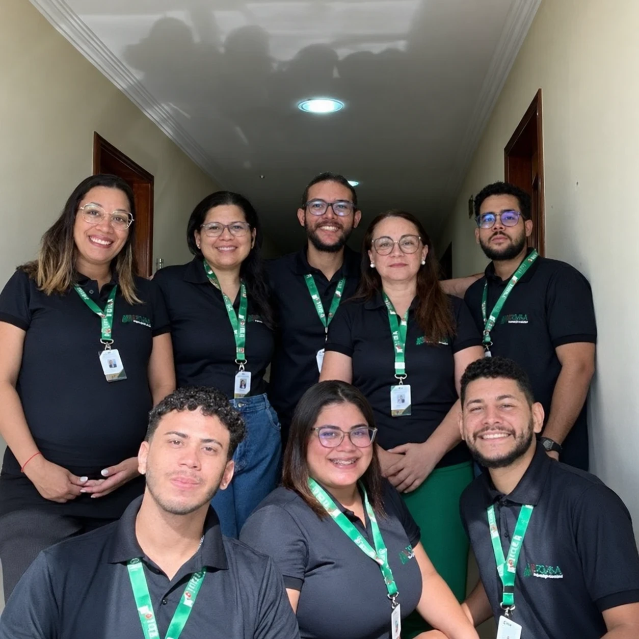 Equipe da Nora Organização Contábil reunida no escritório, com camisas pretas e crachás verdes